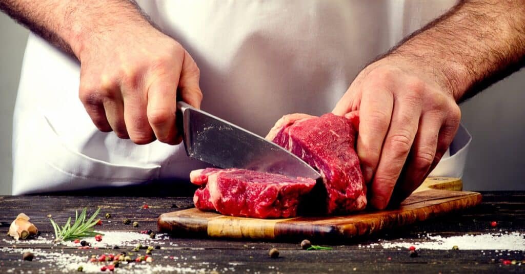 man cutting beef meat