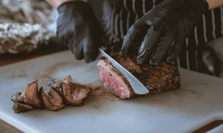 chef cutting meat with knife