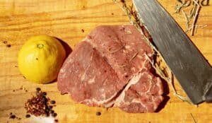 meat lemon and knife on cutting board