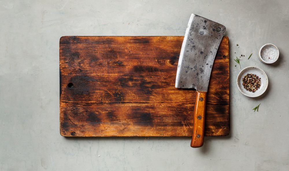 meat cleaver on a empty old dark wooden cutting board