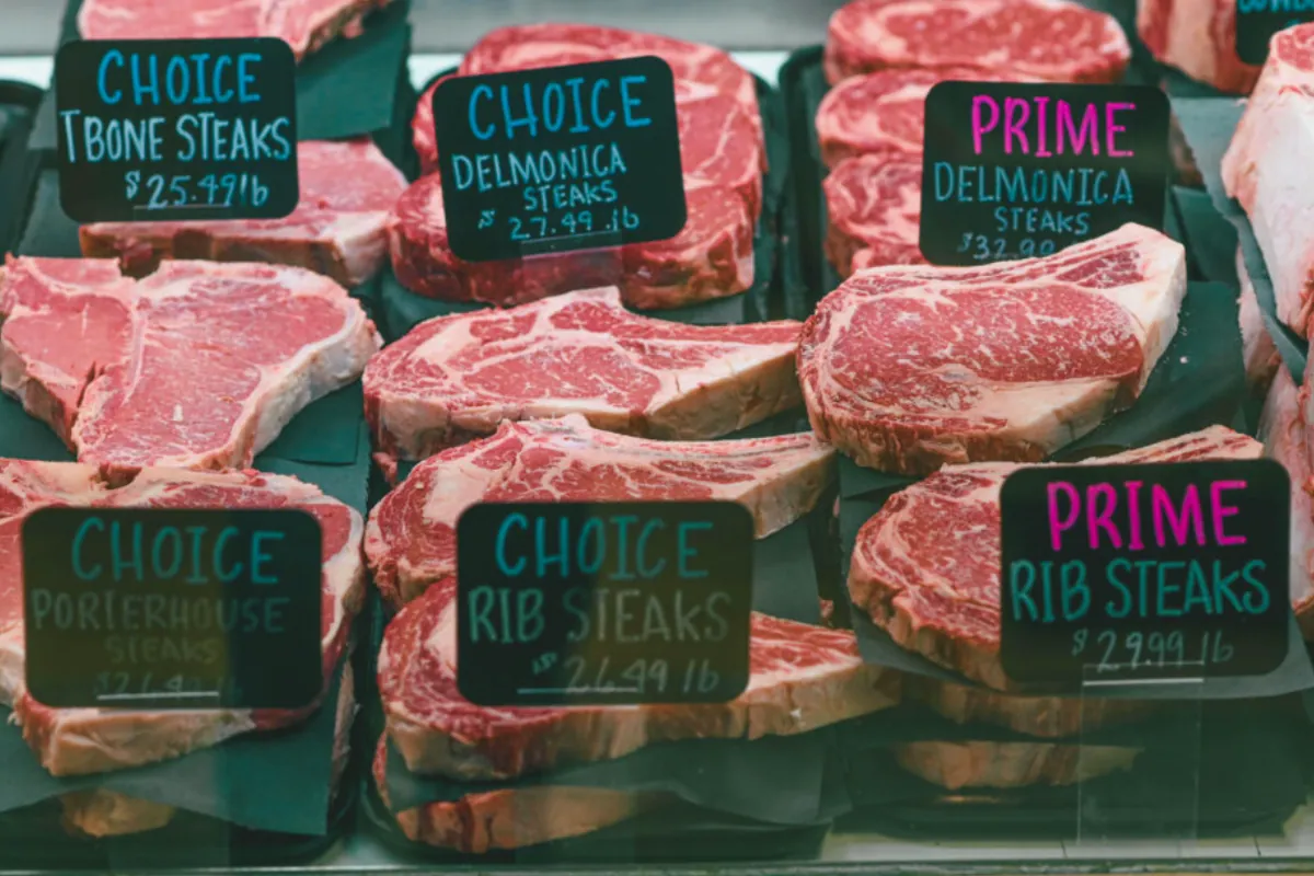 Premium steaks in a butcher case with price tags, showing the wide gap between Wagyu grades
