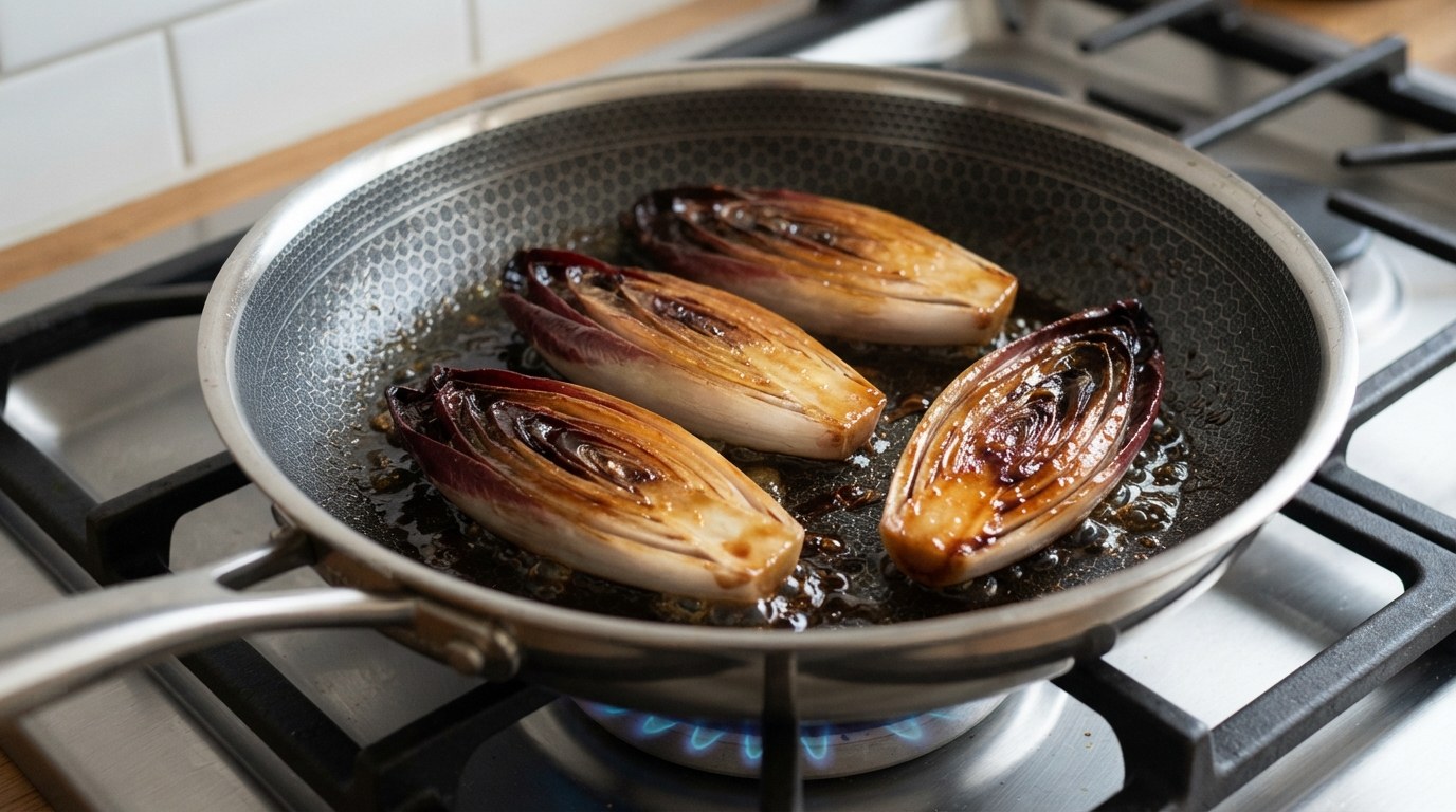 Four halves of red endive caramelized golden brown in a non-stick skillet with a little olive oil and dark balsamic